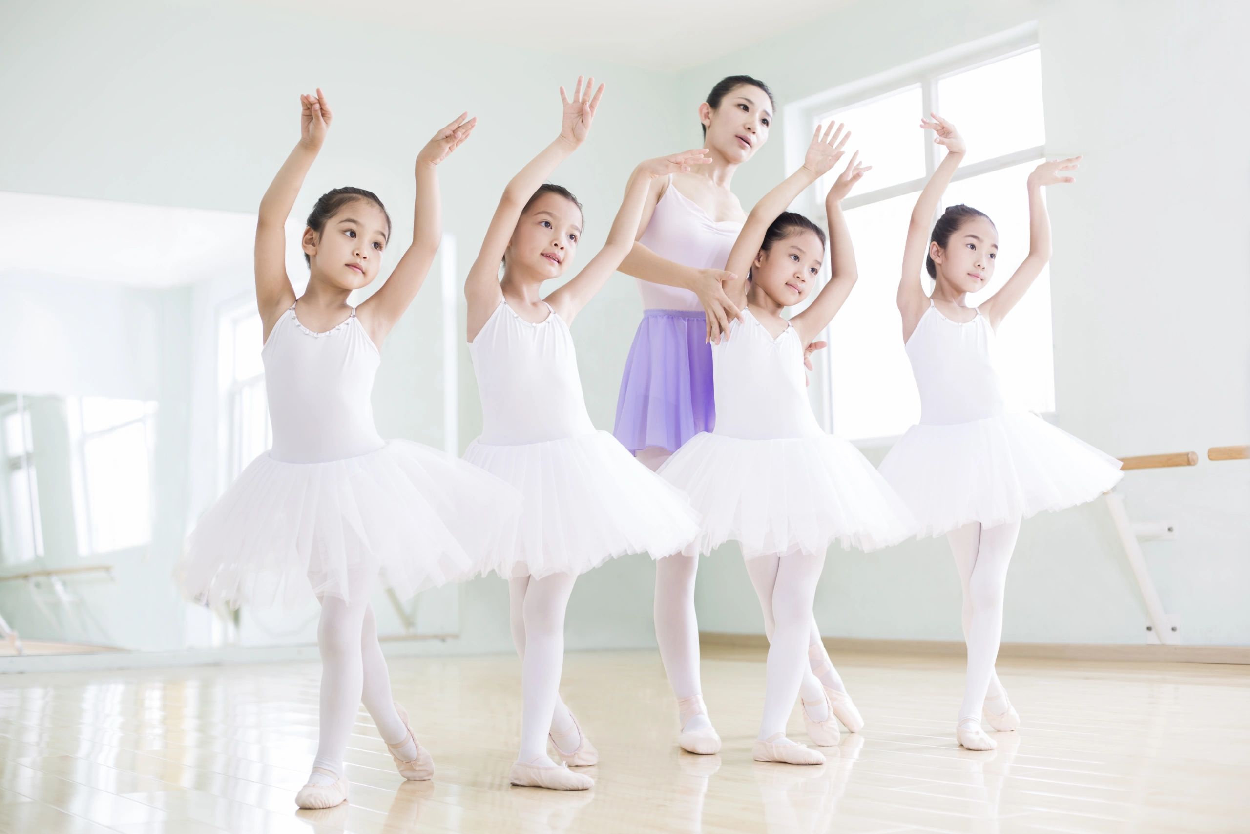 Young ballet students and teacher practicing dance, focusing on student retention - Opus1: Everything You Need to Run Your School in One Place
