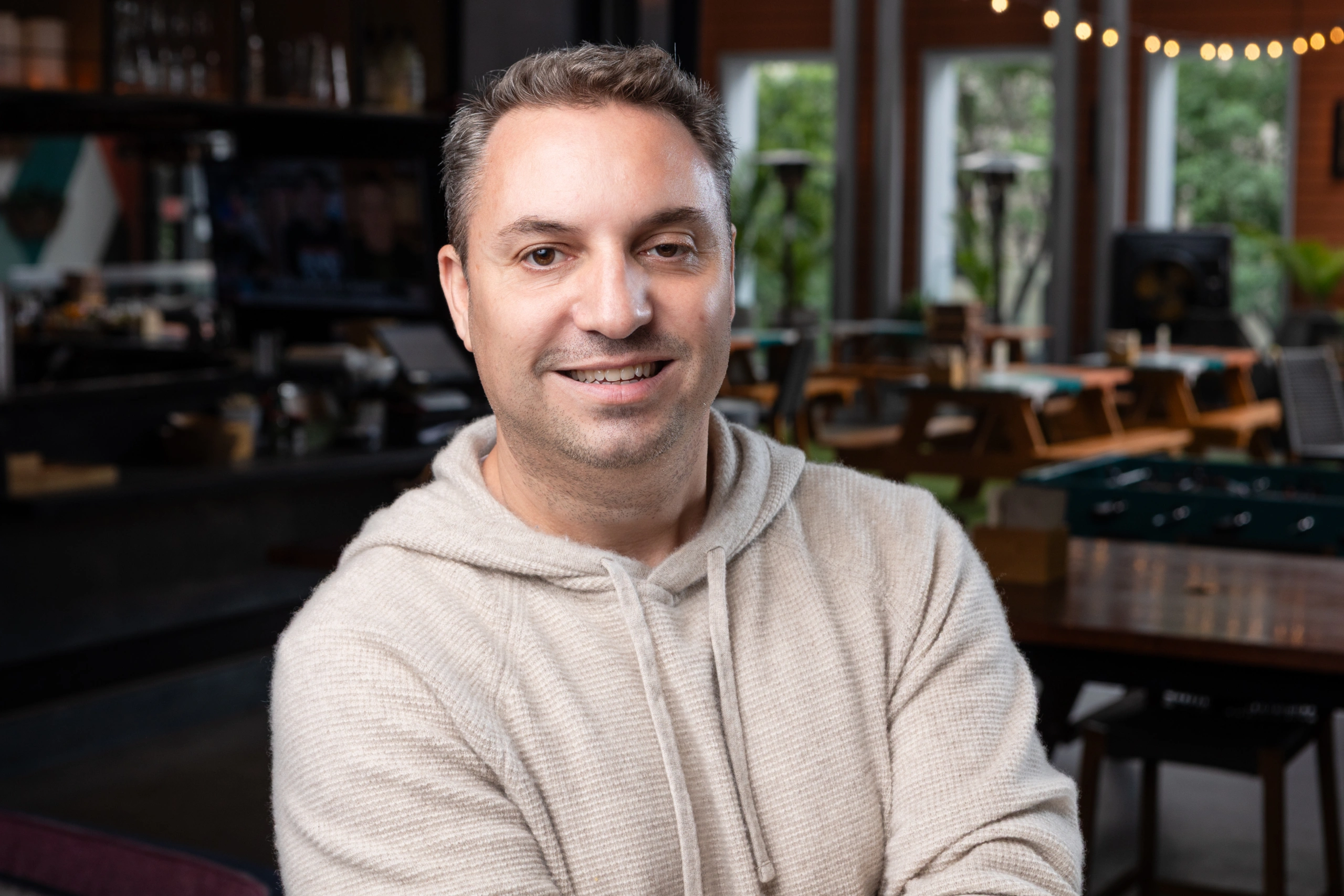 Smiling man in cozy café setting, perfect for casual recital events - Opus1: Everything You Need to Run Your School in One Place