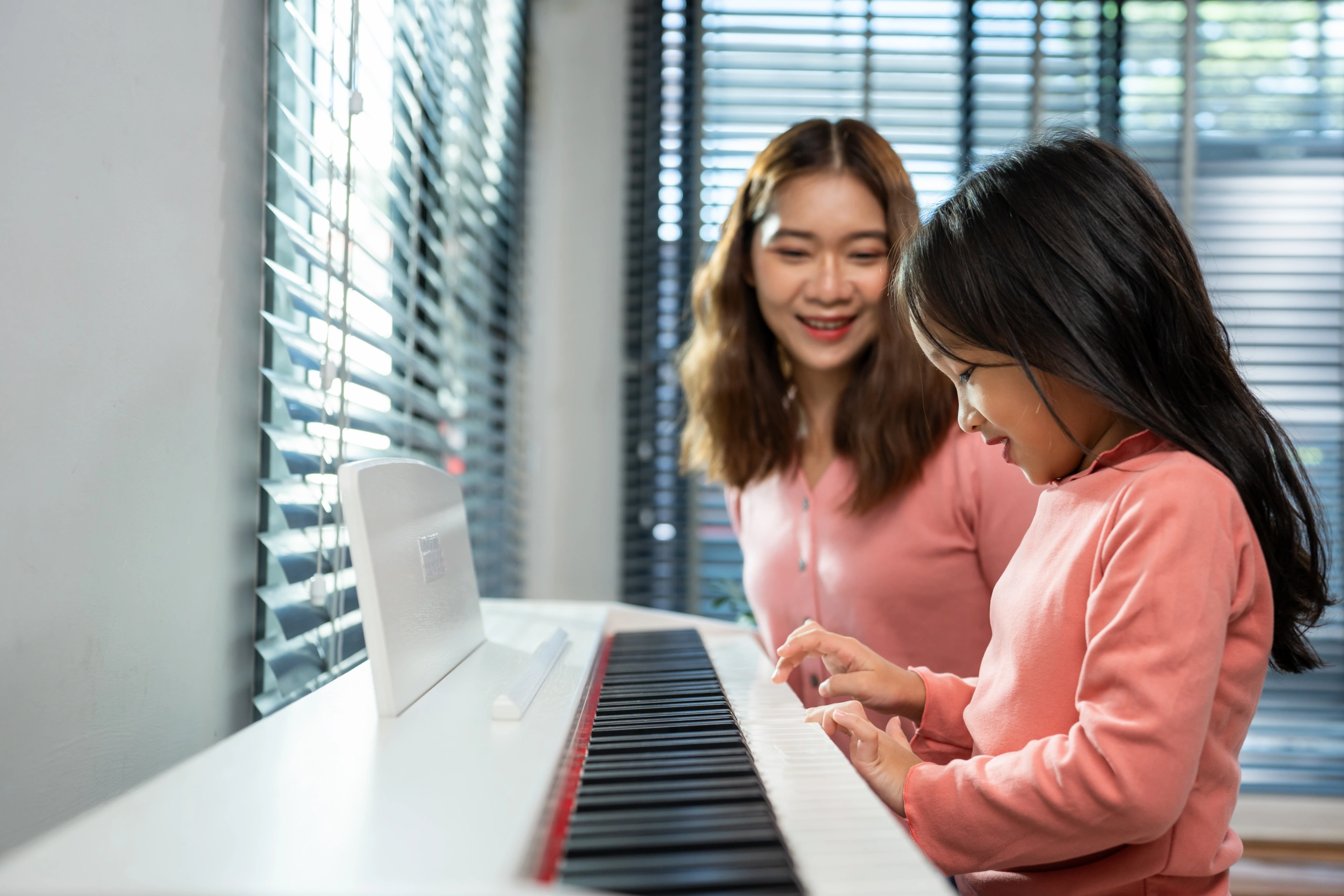 Music school reporting software aids piano lessons for a young student with a teacher - Opus1: Everything You Need to Run Your School in One Place
