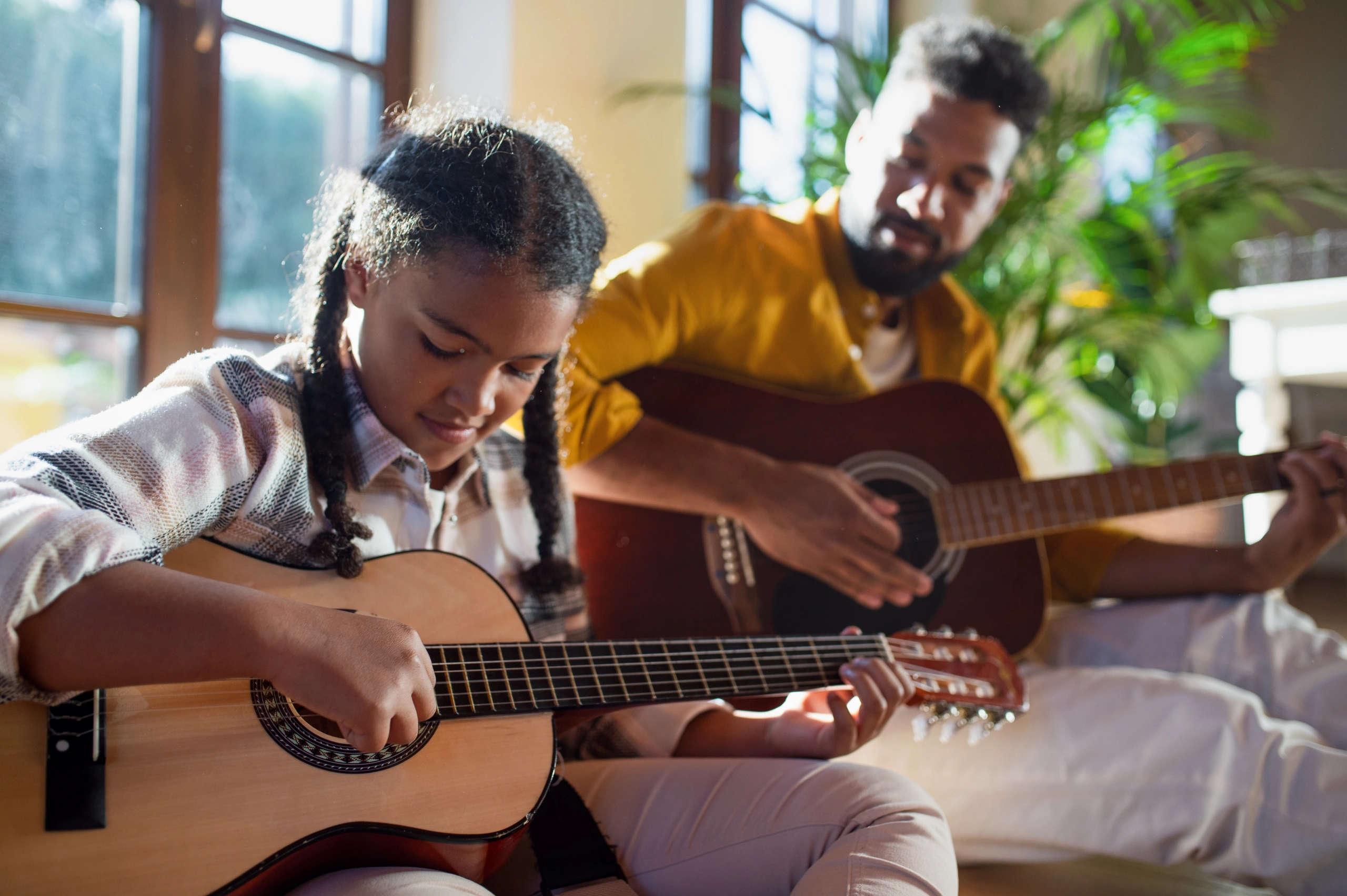Father and daughter playing guitars together during a recital - Opus1: Everything You Need to Run Your School in One Place