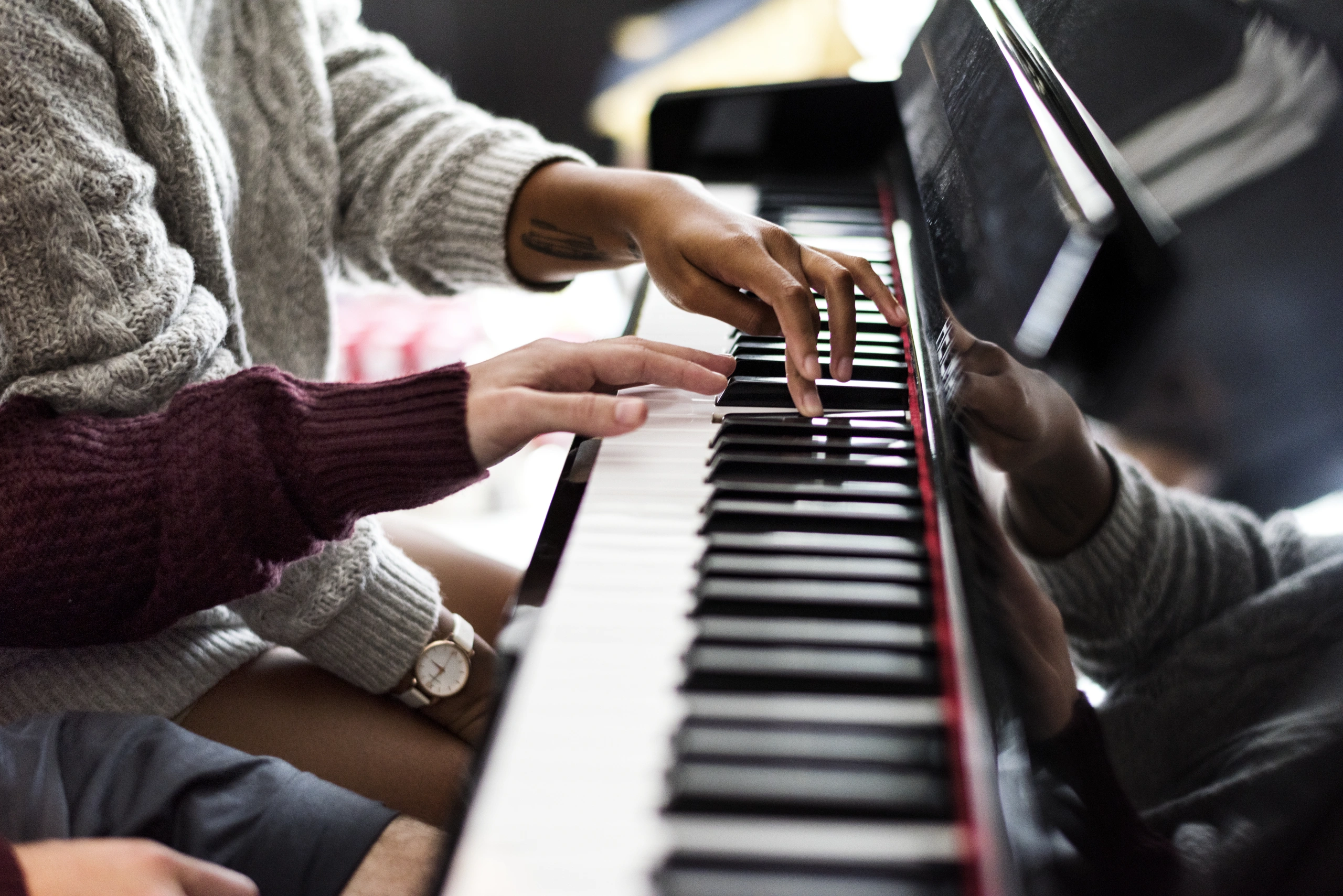 Students at piano using music school reporting software - Opus1: Everything You Need to Run Your School in One Place