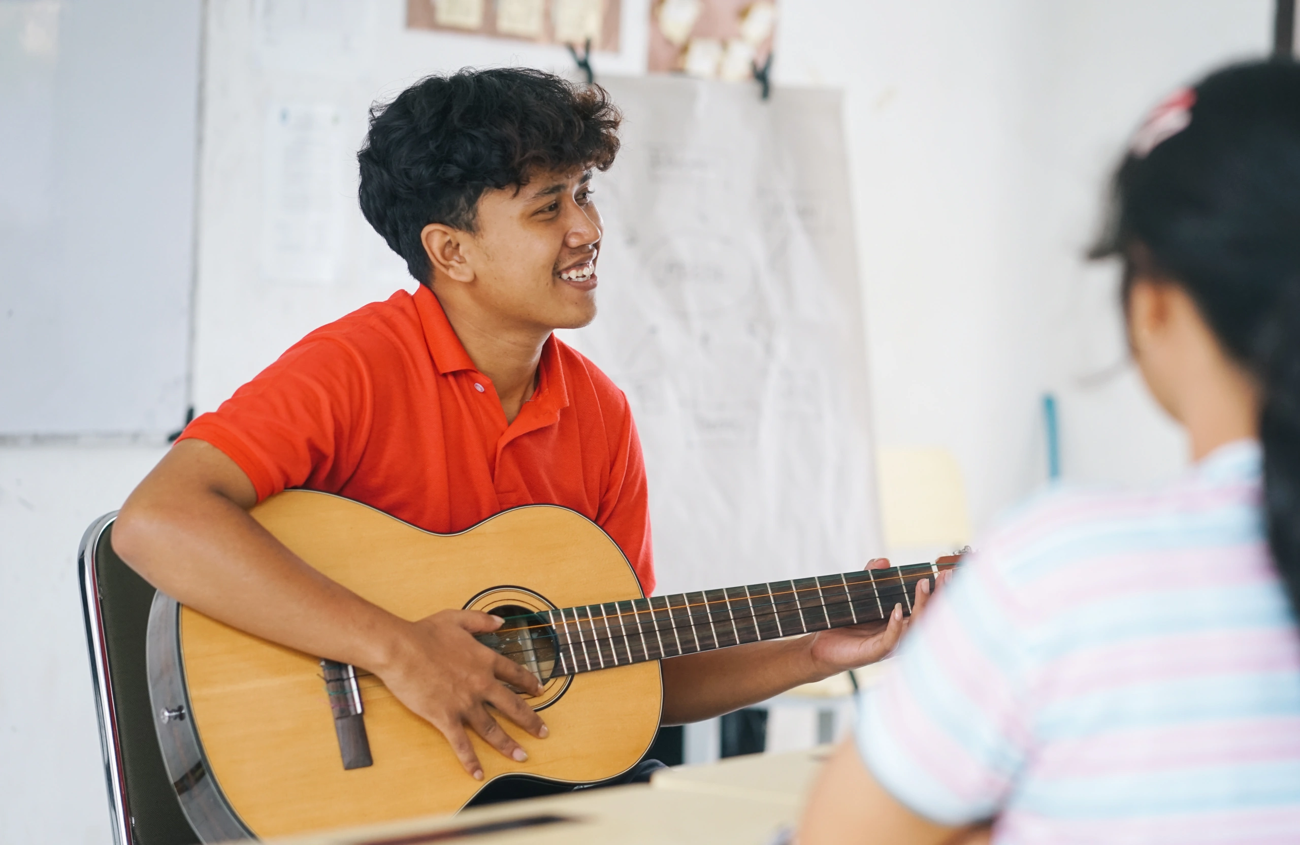 Student playing guitar during music school session - Opus1: Everything You Need to Run Your School in One Place
