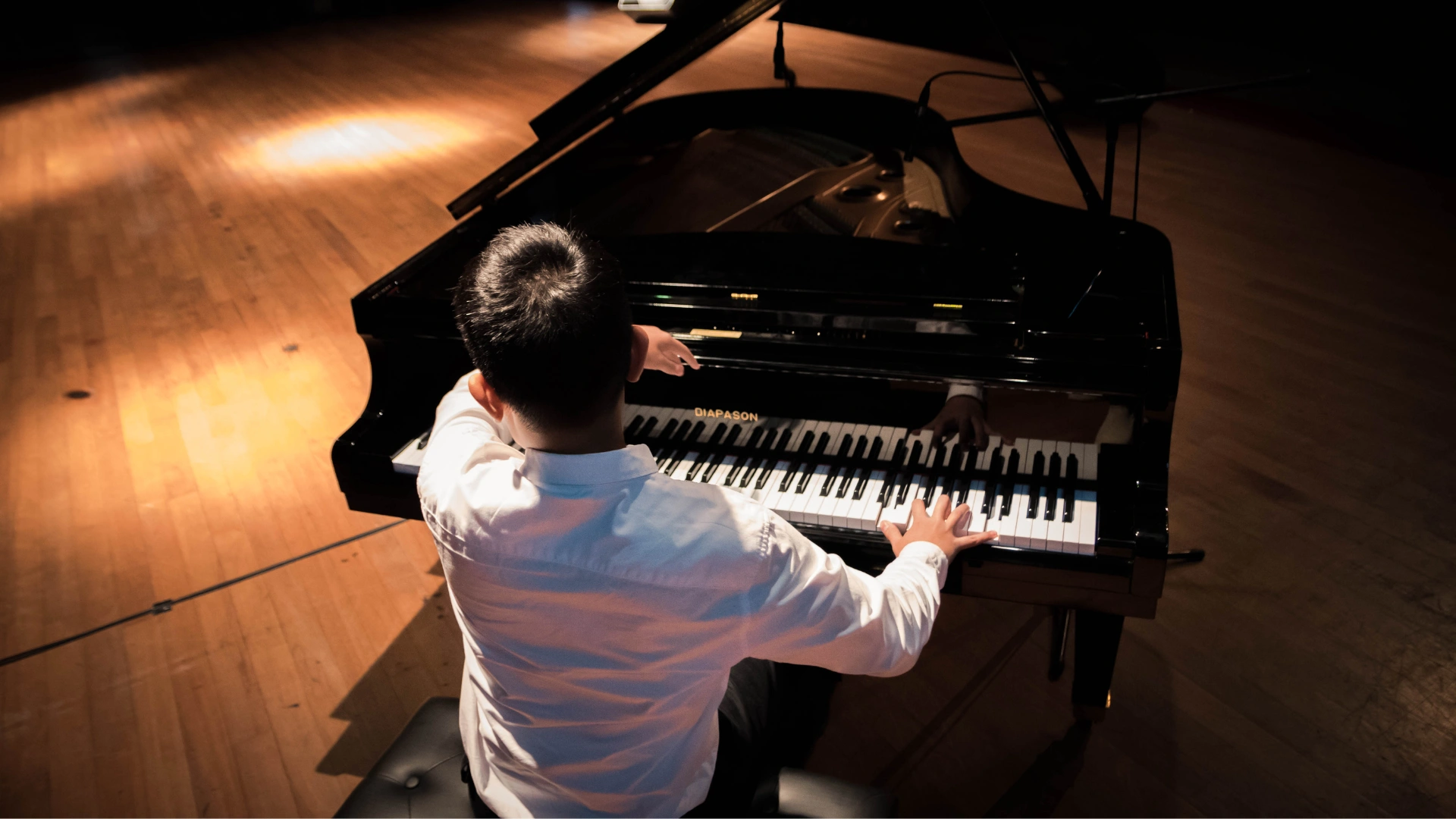 A young student pianist on stage at a recital